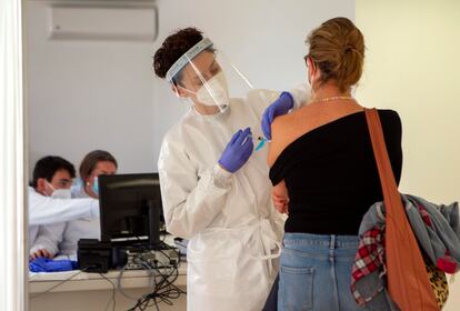 Personal sanitario vacuna a una mujer contra la covid en el recinto del antiguo hospital Son Dureta, este martes en Palma de Mallorca.
