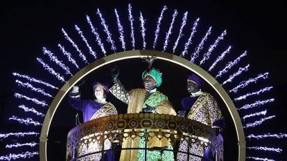 Baltasar saluda desde su carroza junto a dos pajes reales durante la cabalgata de Reyes Magos de 2021 en Madrid.
