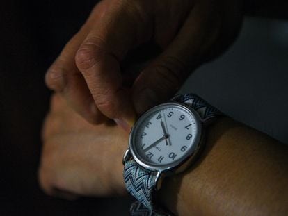 Una persona ajusta su reloj, en una ilustración fotográfica.