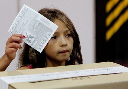 Una niña inserta un voto durante la segunda vuelta de las elecciones presidenciales, en Bogotá (Colombia).