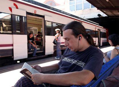 Un hombre escucha música en la estación de cercanías de Chamartín.