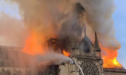 Els bombers treballen en l'extinció de l'incendi que ha consumit una part important de la catedral parisenca aquest dilluns.