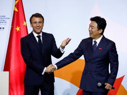 El presidente francés, Emmanuel Macron, saluda al actor chino Huang Bo en la inauguración de un evento al que ha asistido al poco de aterrizar en Pekín este miércoles.