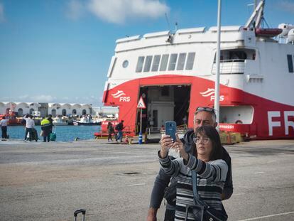 Dos pasajeros se hacen un selfi delante del barco que les llevará hasta Tánger, este jueves.