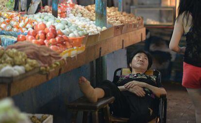 Una vendedora descansa en un mercado de Shanghai