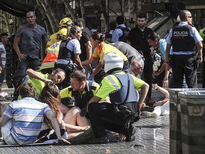 Los servicios de emergencia atienden a algunos de los heridos en La Rambla, Barcelona, tras el atentado.