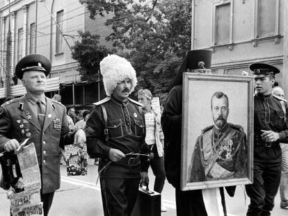 Pie de Foto: Dos soldados (uno de alta graduación), un cosaco y un pope portando un retrato del último zar, en Moscú tras el golpe de estado frustrado de 1991.