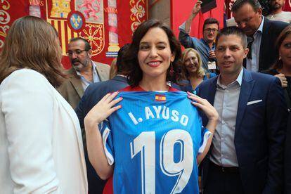 Isabel Díaz Ayuso recibe una camiseta del Getafe, tras tomar posesión de su cargo como presidenta de la Comunidad de Madrid.