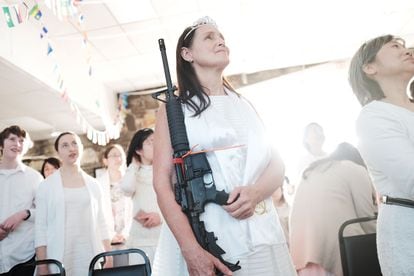 Una mujer sostiene un rifle AR-15 en 2018 en un santuario en Newfoundland (Pennsylvania) de la iglesia de la Unificación, que cree que el AR-15 simboliza la "barra de hierro" en el libro bíblico del Apocalipsis.