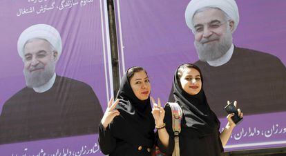 Un par de chicas iran&iacute;es posan para una foto delante de un cartel electoral del actual presidente iran&iacute;, Hasan Rohan&iacute;, en Karaj, provincia de Albroz.