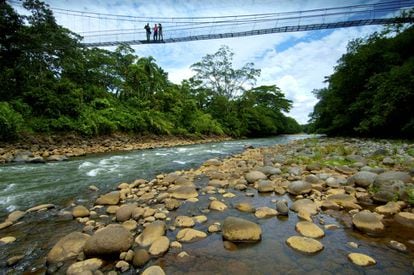 Turistas disfrutan de las vistas desde un puente colgante sobre e río Sarapiquí, en la reserva biológica de Tirimbina, al norte de Costa Rica.