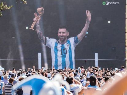 Los argentinos celebran a Messi sosteniendo el Balón de Oro del Mundial a través de una pantalla instalada en Buenos Aires.
