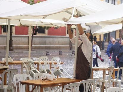 Un camarero coloca los calefactores en una terraza, este viernes en Sevilla.