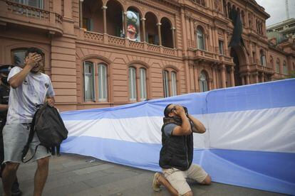 Dos hombres lloran en los alrededores de la capilla ardiente de Maradona, en la Casa Rosada en Buenos Aires.