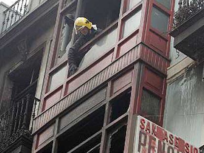 Un bombero inspecciona los pisos incendiados.