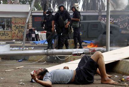 Un hombre herido yace en el suelo mientras las fuerzas de seguridad egipcias se mueven para dispersar el campamento de protesta en manos de partidarios del depuesto presidente Mohamed Morsi y miembros de la Hermandad Musulmana.