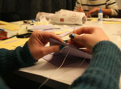Una alumna hace su propio fanzine durante un taller en el Instituto Europeo de Design. Con cartón, hojas de papel coloridas, una aguja e un hilo, ella crea su cuadernillo.