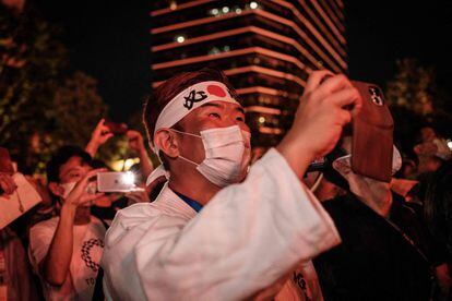 El japonés Kazunori Takishima, que ha estado en todos los Juegos de verano e invierno de los últimos 15 años, observa los fuegos artificiales durante la ceremonia de apertura de los Juegos Olímpicos de Tokio 2020.