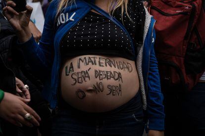 El vientre de una mujer embarazada, en el que lleva escrito: "La maternidad será deseada o no será".