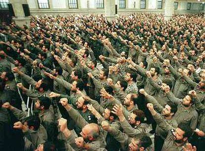 Miembros de los Guardianes de la Revolución, creados para defender el régimen islámico, levantan los puños en un acto militar en Teherán.