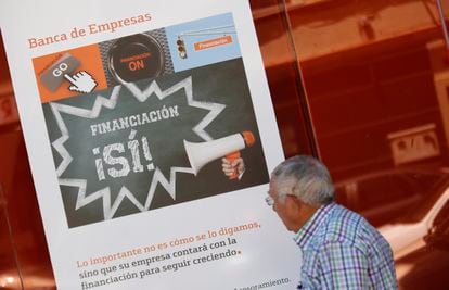 Sucursal bancaria con un cartel de financiación a empresas en una calle de Madrid.