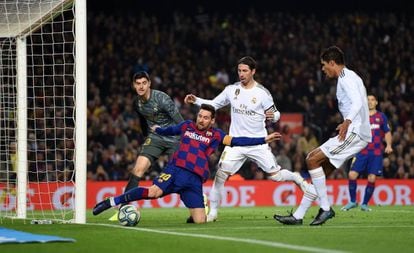 Messi trata de impedir que salga la pelota en el área del Real Madrid.
