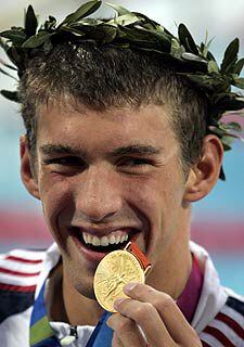 Phelps muestra su primera medalla de oro.