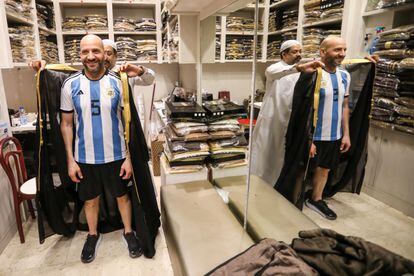 Un aficionado argentino se prueba una réplica de la túnica que recibió Messi del emir Qatar antes de levantar la Copa del Mundo.
