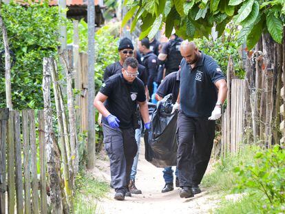 Elementos de la policía retiran un cadáver del sitio donde nueve personas fueron encontradas sin vida en Bahía, Brasil.