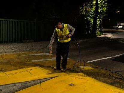 Un trabajador pinta una demarcación vial en un sector residencial de Santiago (Chile), en octubre de 2022.