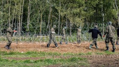 Soldados polacos construyen una valla de alambre de púas a lo largo de la frontera con Bielorrusia, cerca de la aldea de Minkowce, el pasado mes de septiembre.