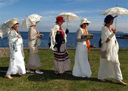 Five women walk through Sandycove in Dublin at a Bloomsday celebration.