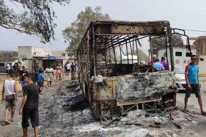 Los residentes pasan junto a un camión quemado en El Kala, cerca de la frontera norte entre Argelia y Túnez, el jueves.
