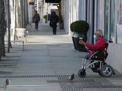 Un hombre con mascarilla pide limosna en una céntrica calle de Madrid, este sábado.