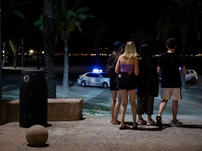 Adolescentes entran a la playa de El Arenal antes de que la Policía Local de Palma de Mallorca cierre los accesos.