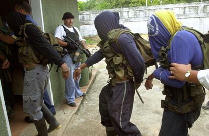 Agentes federales venezolanos montan guardia mientras cinco hombres acusados ​​de ser miembros de los paramilitares colombianos son mostrados a la prensa en Puerto Ayacucho, en abril de 2005. 
