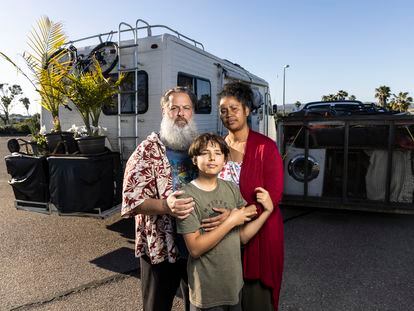 Chris Endres y Julienna Endres posan junto a su hijo Ayden delante de sus vehículos, que son también su casa, en un aparcamiento en San Diego, California.