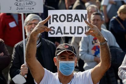 Un manifestante con mascarilla participa en la marcha  ciudadana que recorre este domingo el centro de Madrid.