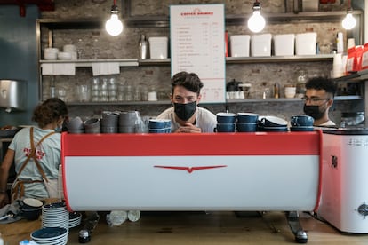 Iker Zago, el dueño del Roast Club Café, junto a dos empleados, en el Eixample barcelonés.