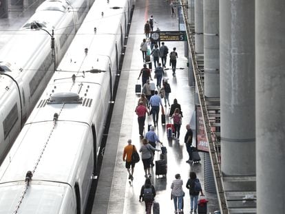 Varios pasajeros con maletas en el andén de un tren en la estación de Puerta de Atocha, el viernes pasado en Madrid.