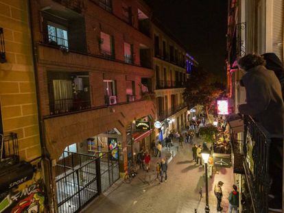 Vecinos de Malasaña contemplan desde un balcón el bullicio en la calle Velarde. 
 