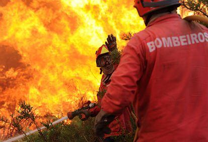 Dos bomberos combaten un incendio en la localidad de Sao Pedro do Sul