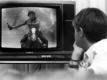 Un niño ve 'Rambo' en televisión en el comedor de su casa en 1993.