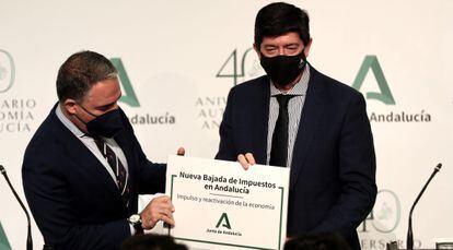 El portavoz de la Junta de Andalucía, Elías Bendodo, y el vicepresidente, Juan Marín, posan junto a un cartel que anuncia una bajada de impuestos en la comunidad, este martes.