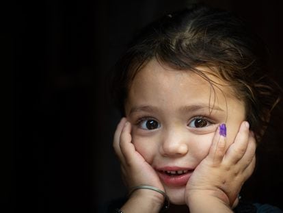 Gul-e-Rukh, de cuatro años, posa mostrando su dedo marcado que indica que ha sido vacunada contra la polio, en Karachi, Pakistán.