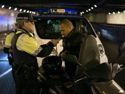 Un agente de la Guardia Urbana de Barcelona hace la prueba de alcoholemia a un motorista. 