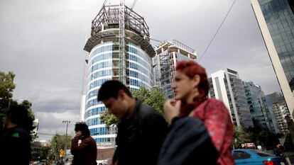 La gente pasa frente a un edificio en construcción en la Ciudad de México, México.