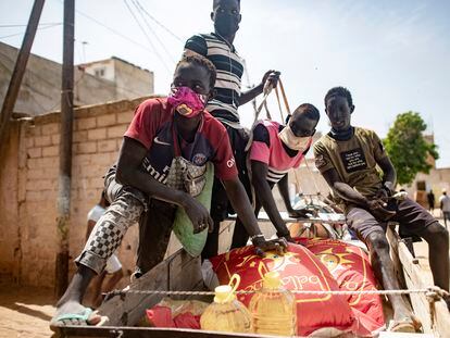 Una familia se lleva productos de primera necesidad durante el reparto de comida puesto en marcha por el Gobierno senegalés, el pasado martes en Dakar.