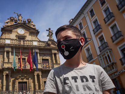 Un niño con mascarilla posa delante del Ayuntamiento de Pamplona, durante el primer fin de semana de fase 2 en la desescalada de la pandemia por covid-19.