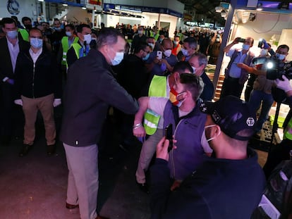 Felipe VI saluda con el codo a uno de los trabajadores de Mercamadrid durante su recorrido por las instalaciones.